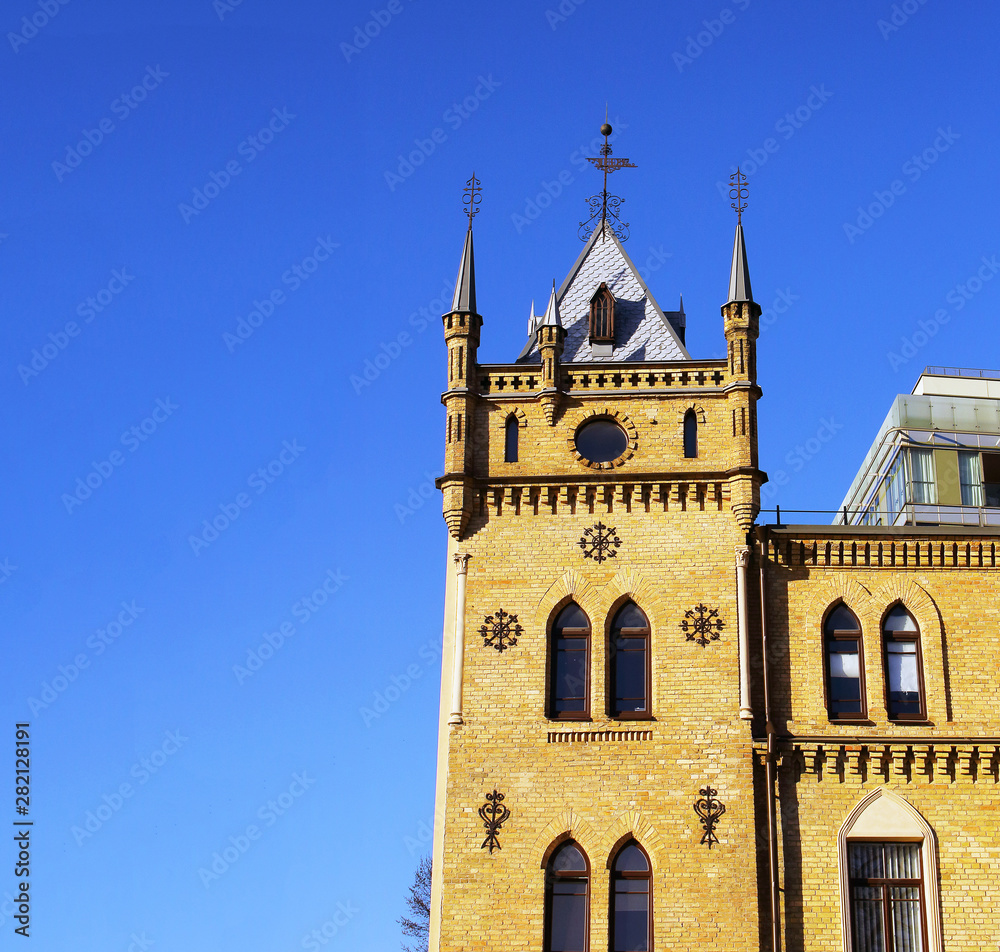 Old gothic castle tower top on blue sky background
