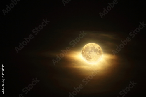 Detailed full moon in dark cloudy sky