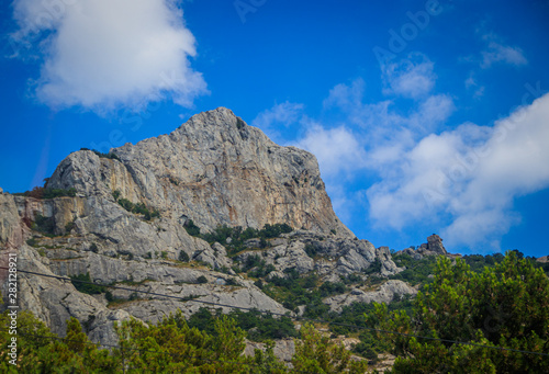 Russian mountains. Crimea. Summer mountains background. Forest and mountains in the sun on the background of a cloudy sky above the peninsula of Crimea. Sunny  bright  saturated raster photo
