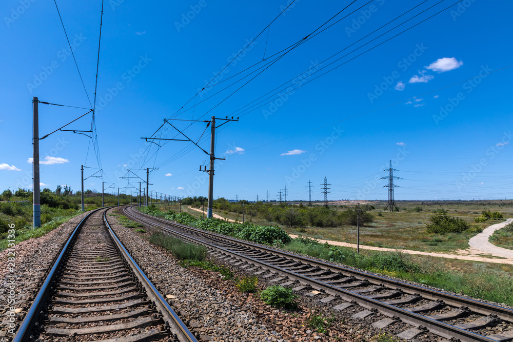 The summer landscape of the railway in the steppe or prairie with bue sky in sunny weather The summer landscape of the railway in the steppe or prairie with bue sky in sunny weather