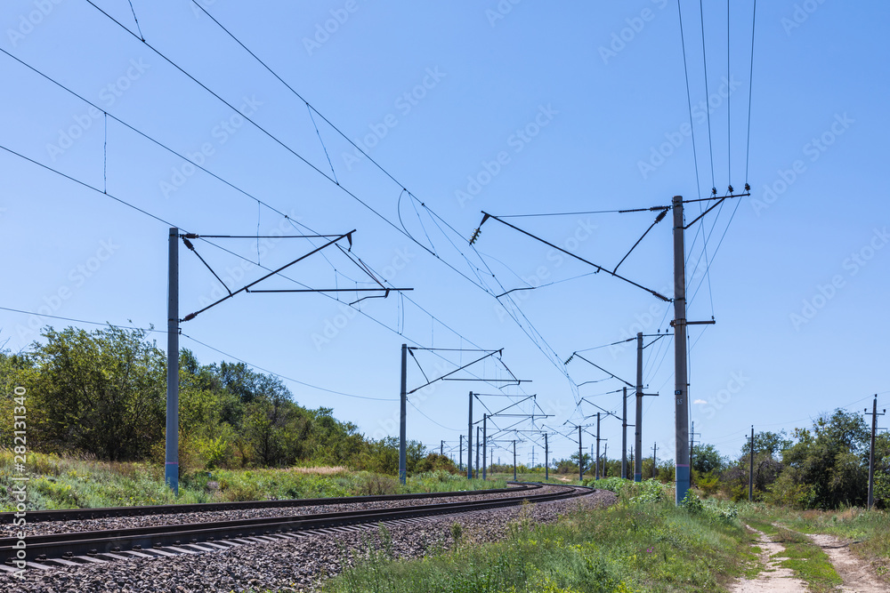 The summer landscape of the railway in the steppe or prairie with bue sky in sunny weather