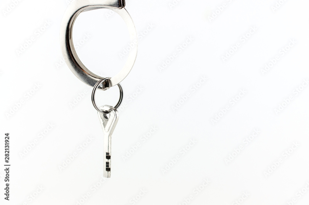 the key of the house in handcuffs, isolated on white background the key of the house in handcuffs, isolated on white background