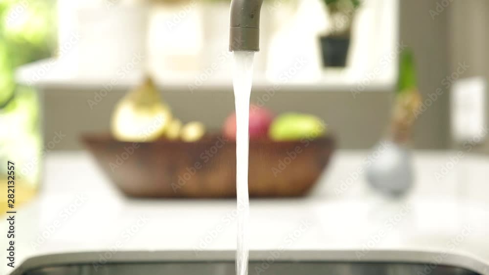 Medium shot of a glass filling up with water from a faucet. Medium shot of a glass filling up with water from a faucet.