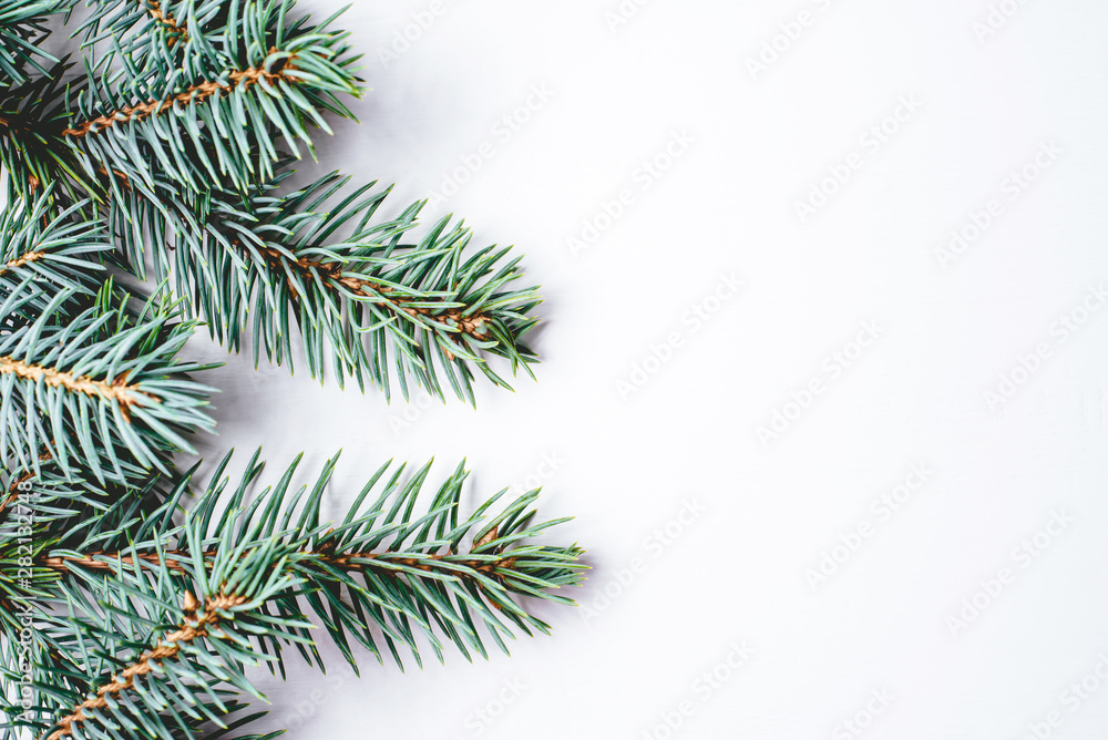 Fir branches on white wooden background. Christmas wallpaper. Flat lay, copy space.