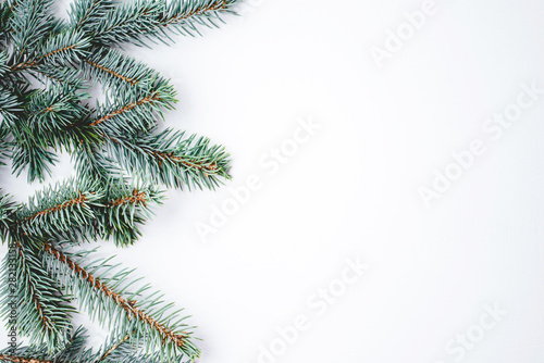 Fir branches on white wooden background. Christmas wallpaper. Flat lay  copy space.