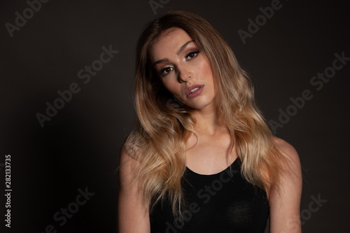 Beauty portrait of a gorgeous young woman over dark background