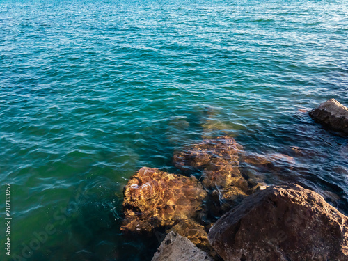 Beautiful sea waves beat against large coastal stones on a sunny summer day. Black Sea.