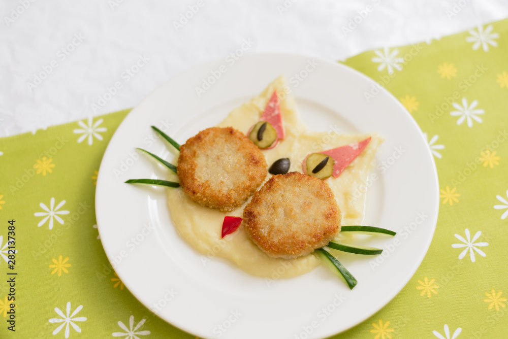 Baby puree in the form of a cat. Mashed potatoes. Children's menu on a green background. Baby puree in the form of a cat. Mashed potatoes. Children's menu on a green background.