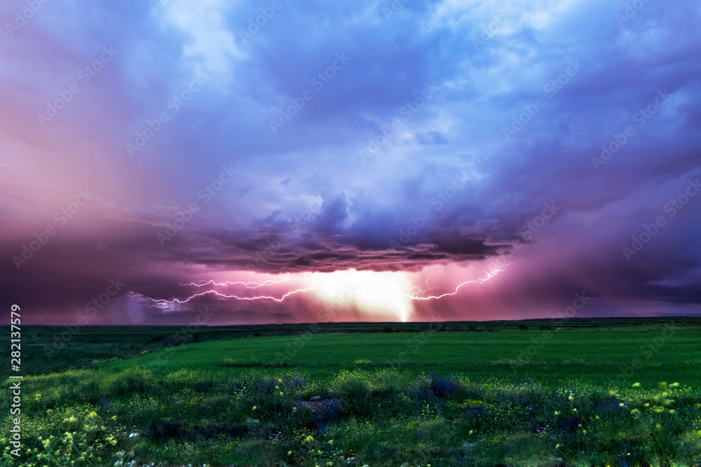 Lightning striking the ground in a grass fields.