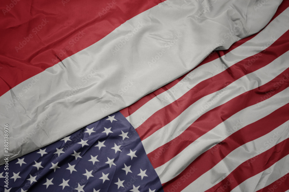 Obraz premium waving colorful flag of united states of america and national flag of indonesia.