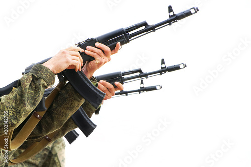 Three military machine gunners reload weapons and shoot on a light background. Threat of conflict photo