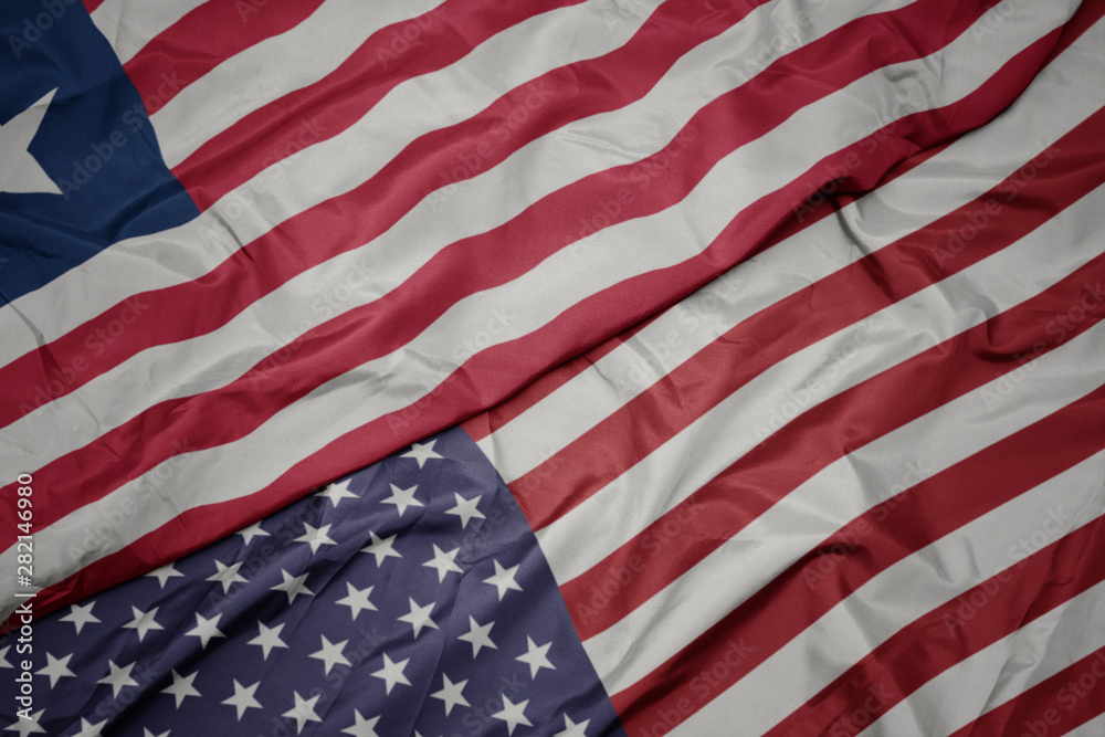 Obraz premium waving colorful flag of united states of america and national flag of liberia.