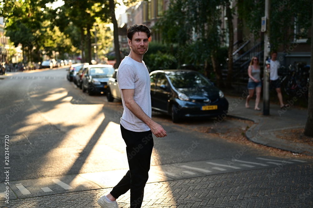 Spontaneous and happy Dutch male student walking down a traditional ...