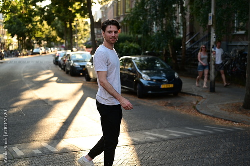 Photography Spontaneous and happy Dutch male student walking down a traditional street in Am