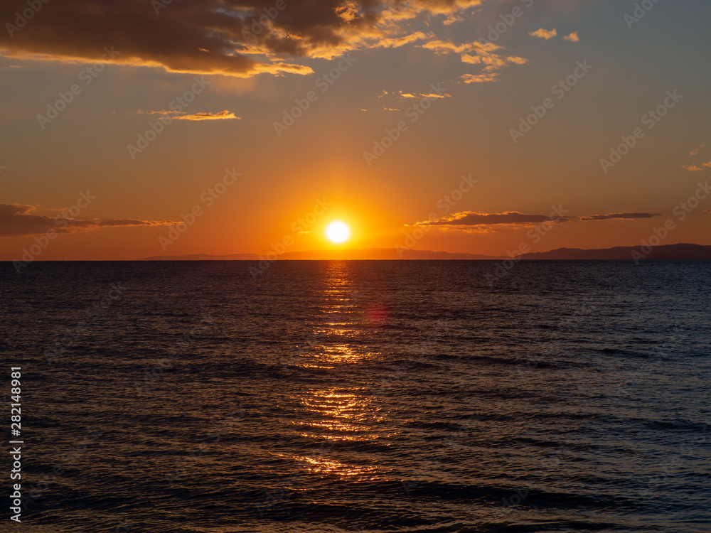 Amazing sunset over the sea with distant islands in the background