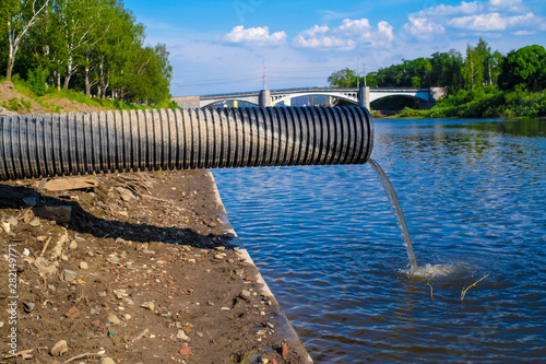 Sewage flows down to the river photo