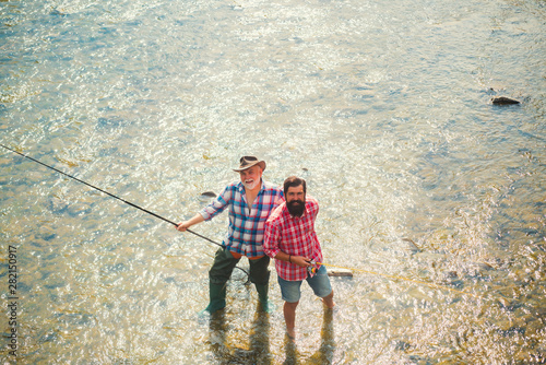 Fly fishing. Fly fisherman using fly fishing rod in beautiful river. Difference between fly fishing and regular fishing.