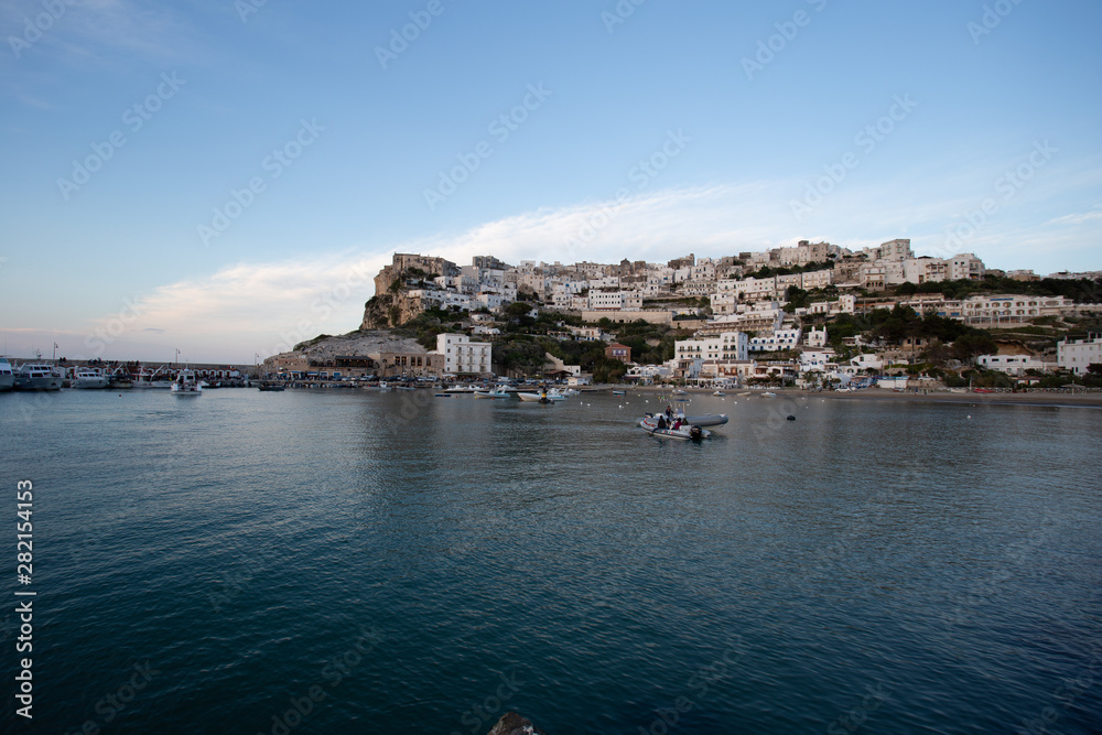 Fototapeta premium Setting sun lit city over the sea