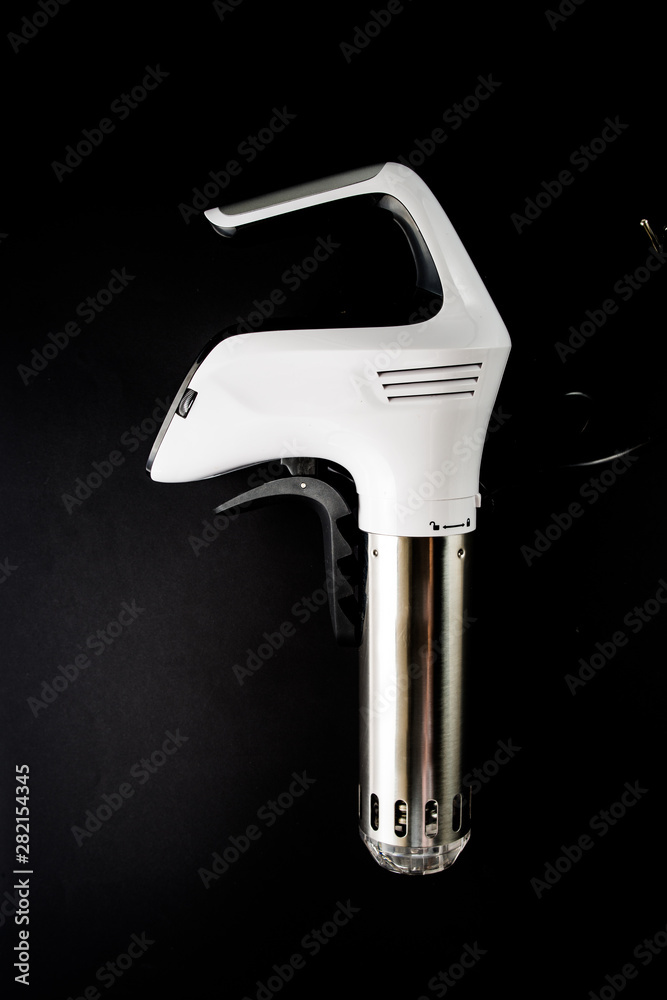 Sous vide stick or rooner close up, top view of a modern utensil for the sous vide cooking technique, ooner, precision immersion circulator. Isolated on clean background. Sous vide stick or rooner close up, top view of a modern utensil for the sous vide cooking technique, ooner, precision immersion circulator. Isolated on clean background.