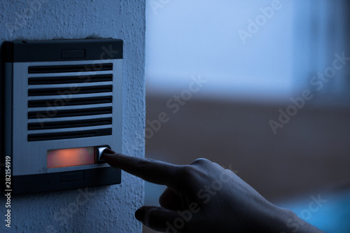 Person calling the bell of a home. Urban technology.