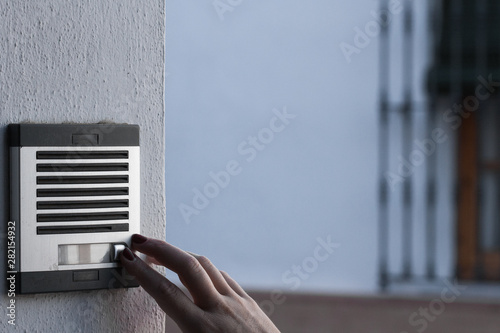 Person calling the bell of a home. Urban technology.