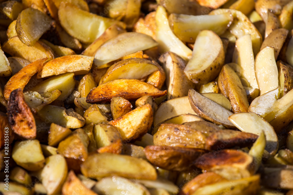Roast potatoes in a large pan. Delicious food at the festival. Many potatoes on the table in a metal tray. Roast potatoes in a large pan. Delicious food at the festival. Many potatoes on the table in a metal tray.