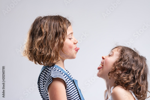 Bilde på lerret Two naughty young girls sticking out their tongues