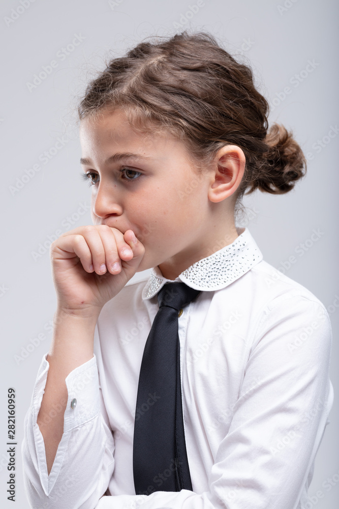 Thoughtful little schoolgirl with hand to mouth Thoughtful little schoolgirl with hand to mouth