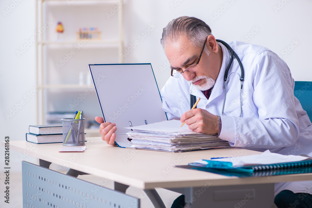 Old male doctor working in the clinic Old male doctor working in the clinic