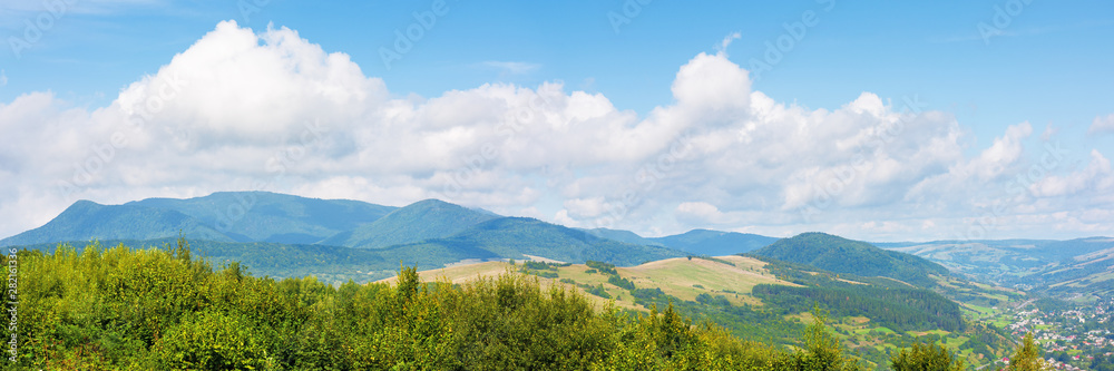 beautiful countryside in mountain. sunny weather. clouds on the blue sky. lovely panoramic landscape with ridge and village in the valley