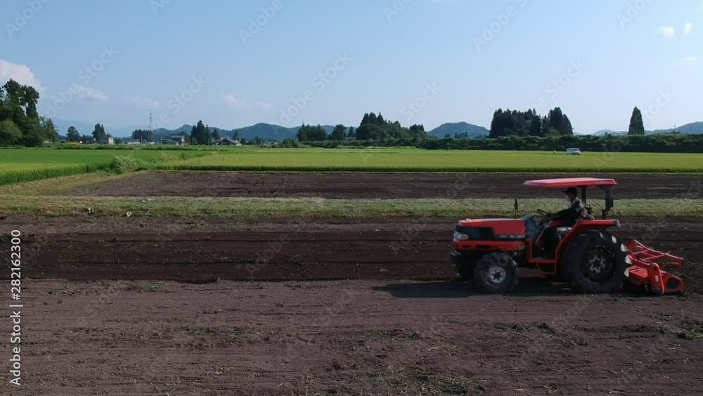 トラクターで農地を耕す日本人の男性 農業 トラクターで農地を耕す日本人の男性 農業