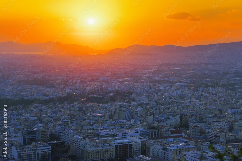 Panorama of Athens at sunset. Beautiful cityscape with seashore under the red sunset sky. Travel panoramic photography view over the city at night from Lycabettus hill. Athens skyline, Greece Europe.
