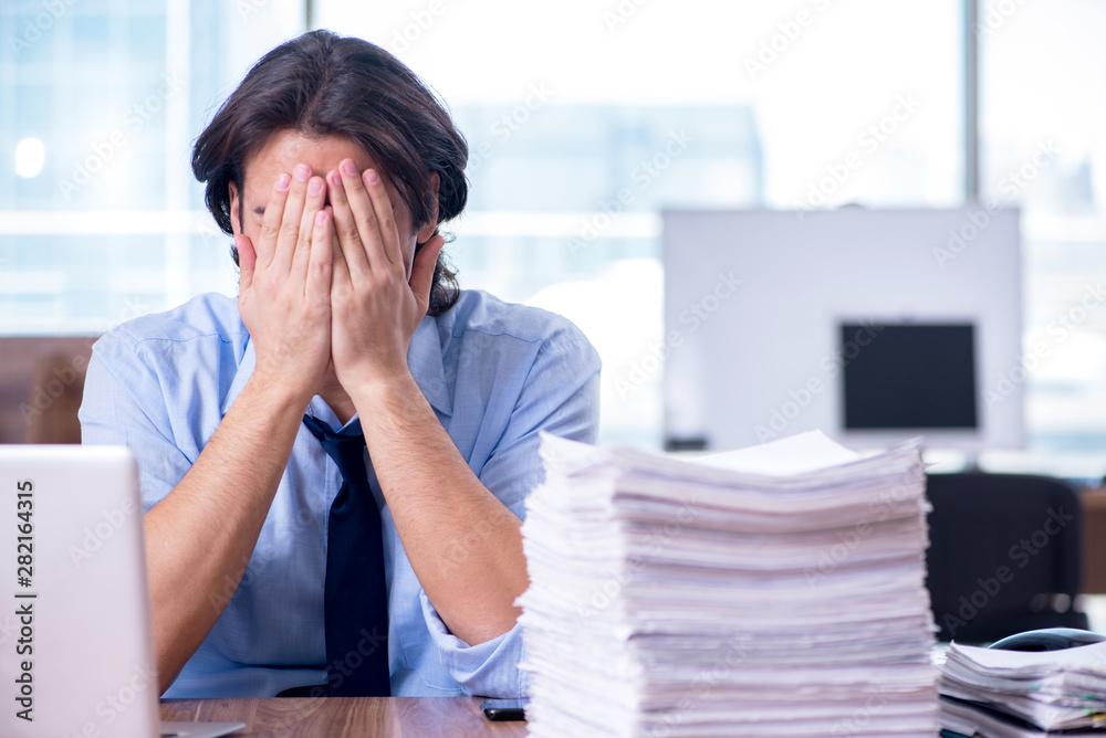 Young employee unhappy with excessive work Young employee unhappy with excessive work