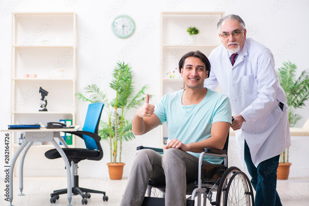 Male patient in wheel-chair visiting old doctor Male patient in wheel-chair visiting old doctor