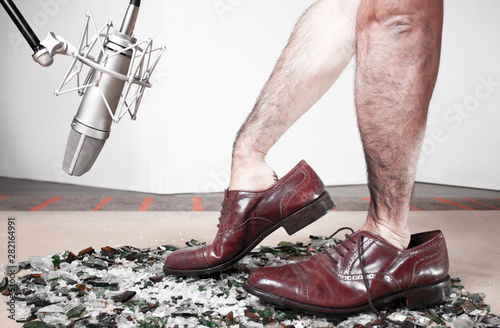 Foley man steps recording with soundman hands inside male dress shoes. 