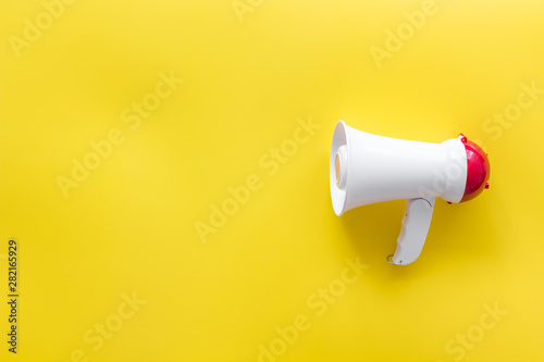 Attract attention with megaphone on yellow background top view copyspace