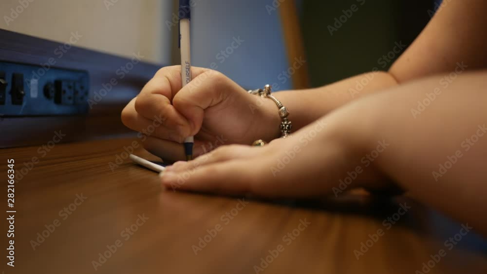 Woman writing dramatic note on desk