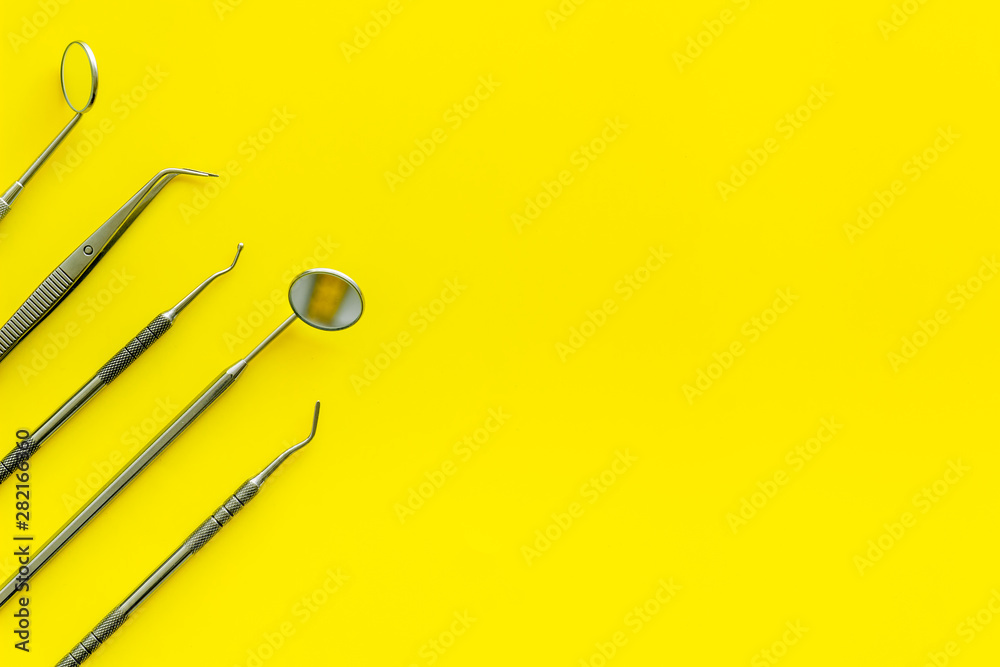 Dentist tools for cure teeth on yellow background top view copy space Dentist tools for cure teeth on yellow background top view copy space