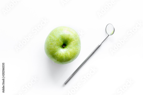 Dentist tools for cure teeth and apple on white background top view photo