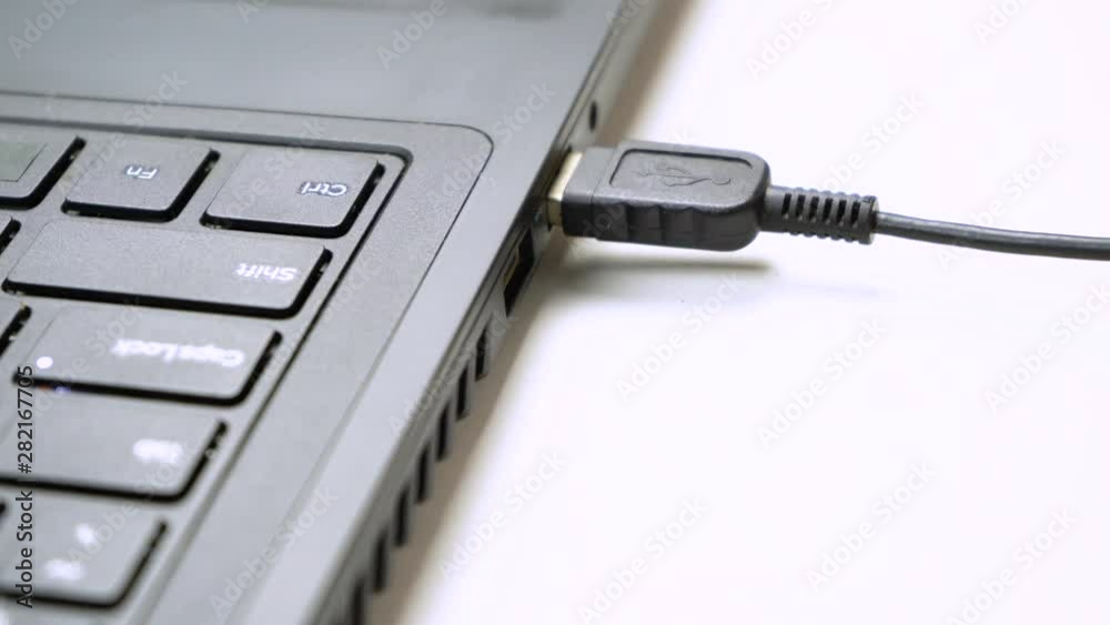 USB flash drive connected to a Laptop. Hand disconnecting Usb flash drive cable to computer