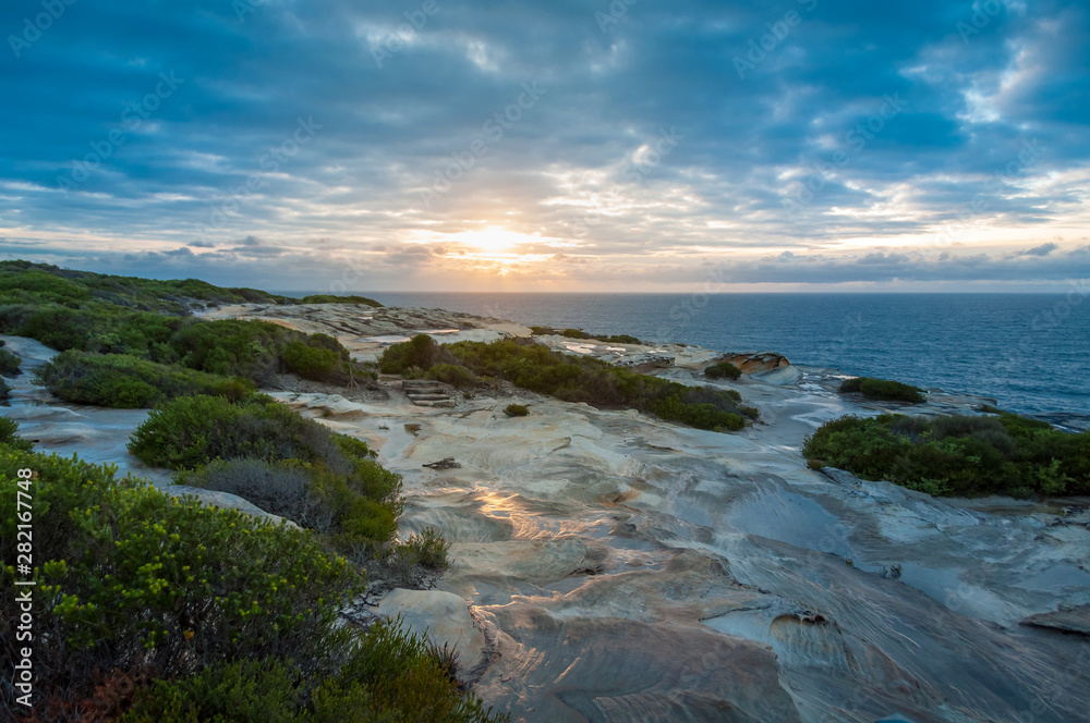 Beuatiful sunrise seascape with rocky coastline and open ocean