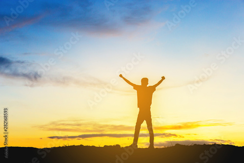 Silhouette of Man Celebration Success Happiness on a mountain top Evening Sky Sunset Background, Sport and active life Concept