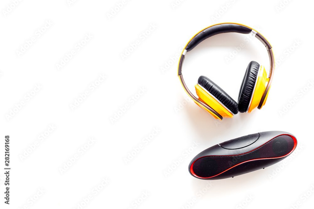Wireless headphones and portable speaker on white background top view copyspace