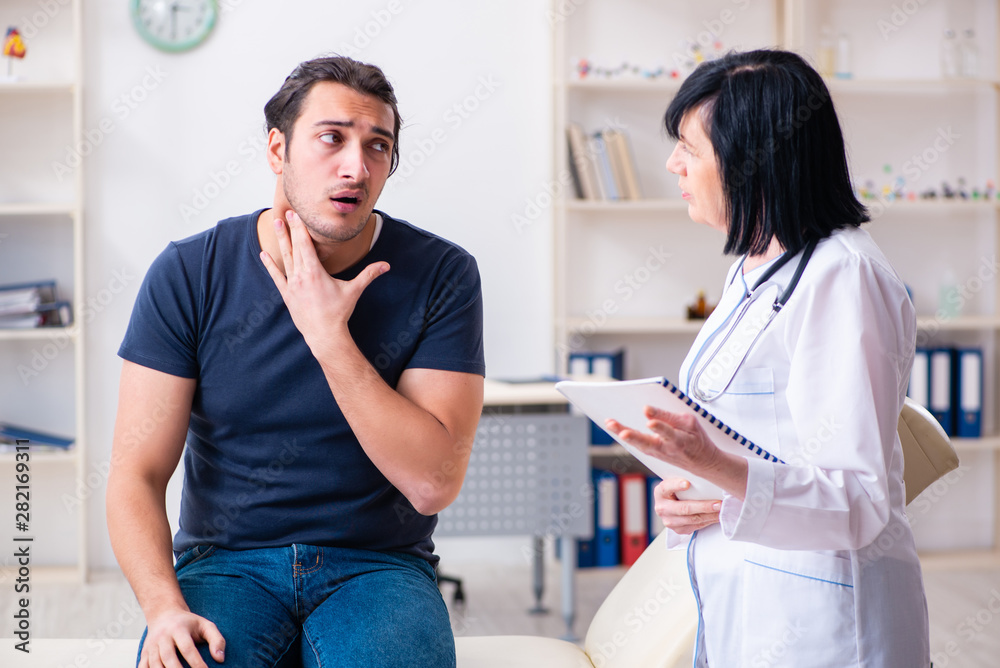 Fototapeta premium Young male patient visiting aged female doctor
