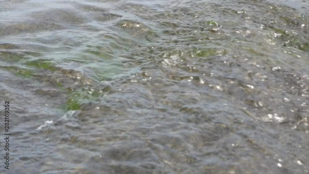 Clear, fresh, clean water in a stream flowing over rocks, close up. Clear, fresh, clean water in a stream flowing over rocks, close up.