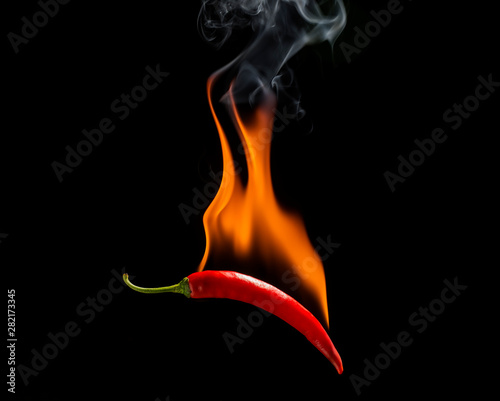 Red chili with a flame on a black background, the concept of spicy