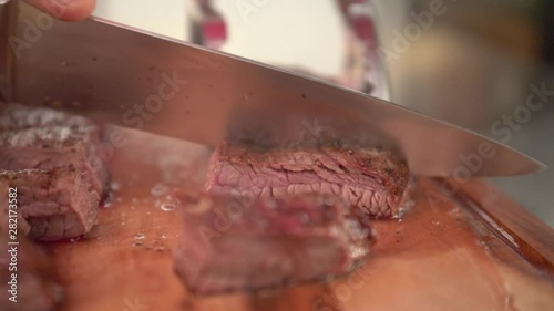 Chef cutting hot medium rare flank beef, slow motion photo