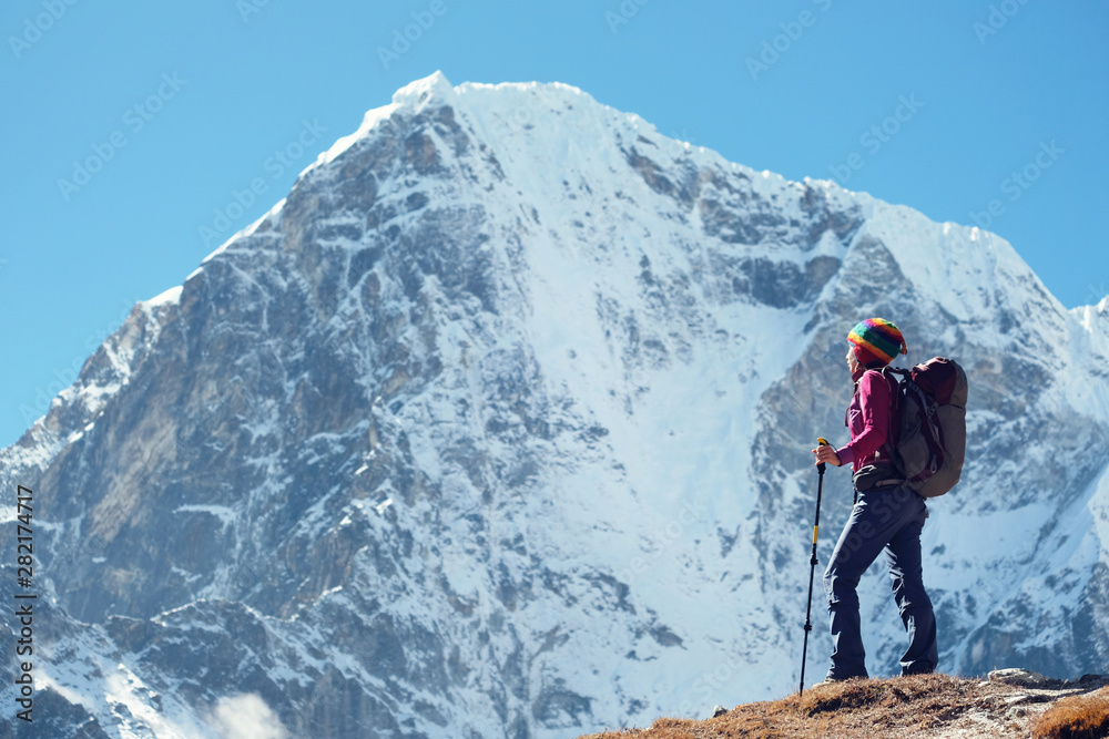 Hiking in Himalaya mountains. Woman Traveler with Backpack hiking in the Mountains. Nepal, Everest region Hiking in Himalaya mountains. Woman Traveler with Backpack hiking in the Mountains. Nepal, Everest region