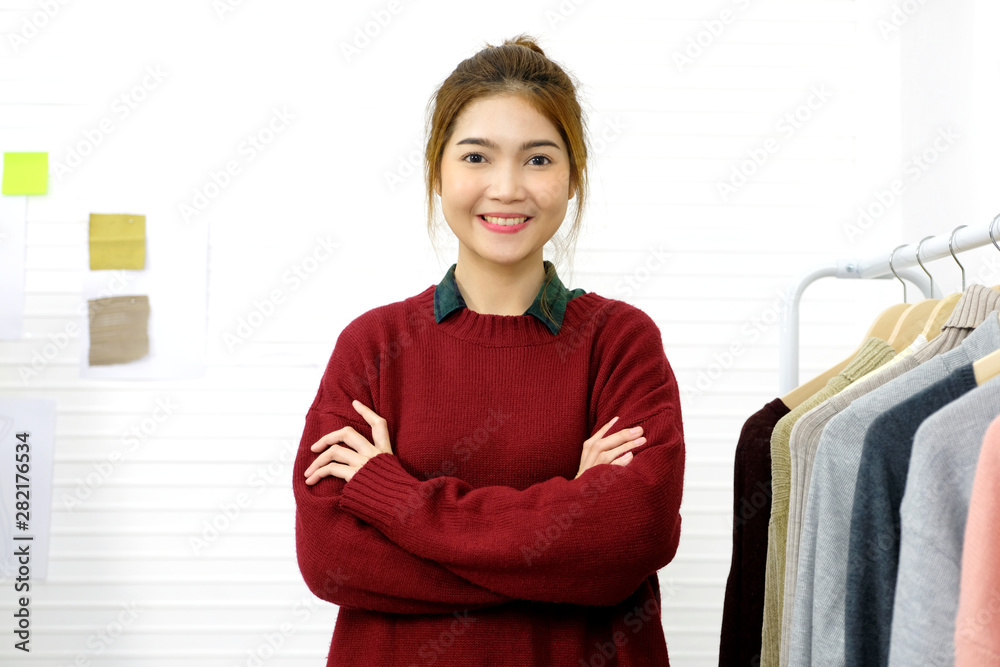 Portrait of happy fashion designer, Young asian woman, business owner, in  casual smiling with new collection clothing at studio showroom office ,  Small business in fashion industry Stock Photo