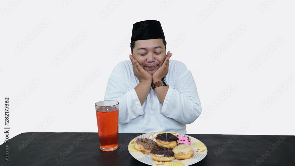 Portrait of overweight muslim man with head cap or songkok pray before eat and drink for islam break fasting Portrait of overweight muslim man with head cap or songkok pray before eat and drink for islam break fasting